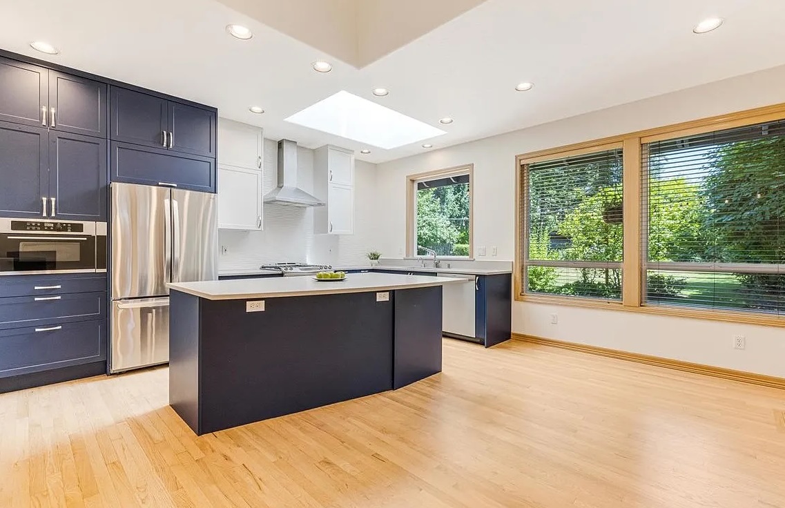 Clean modern kitchen after post-construction cleaning with hardwood floors and updated cabinets