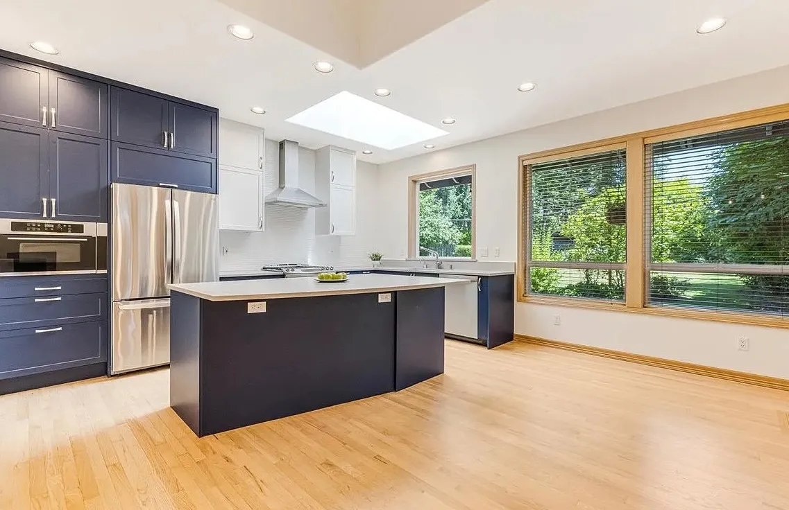 Clean modern kitchen after post-construction cleaning with hardwood floors and updated cabinets